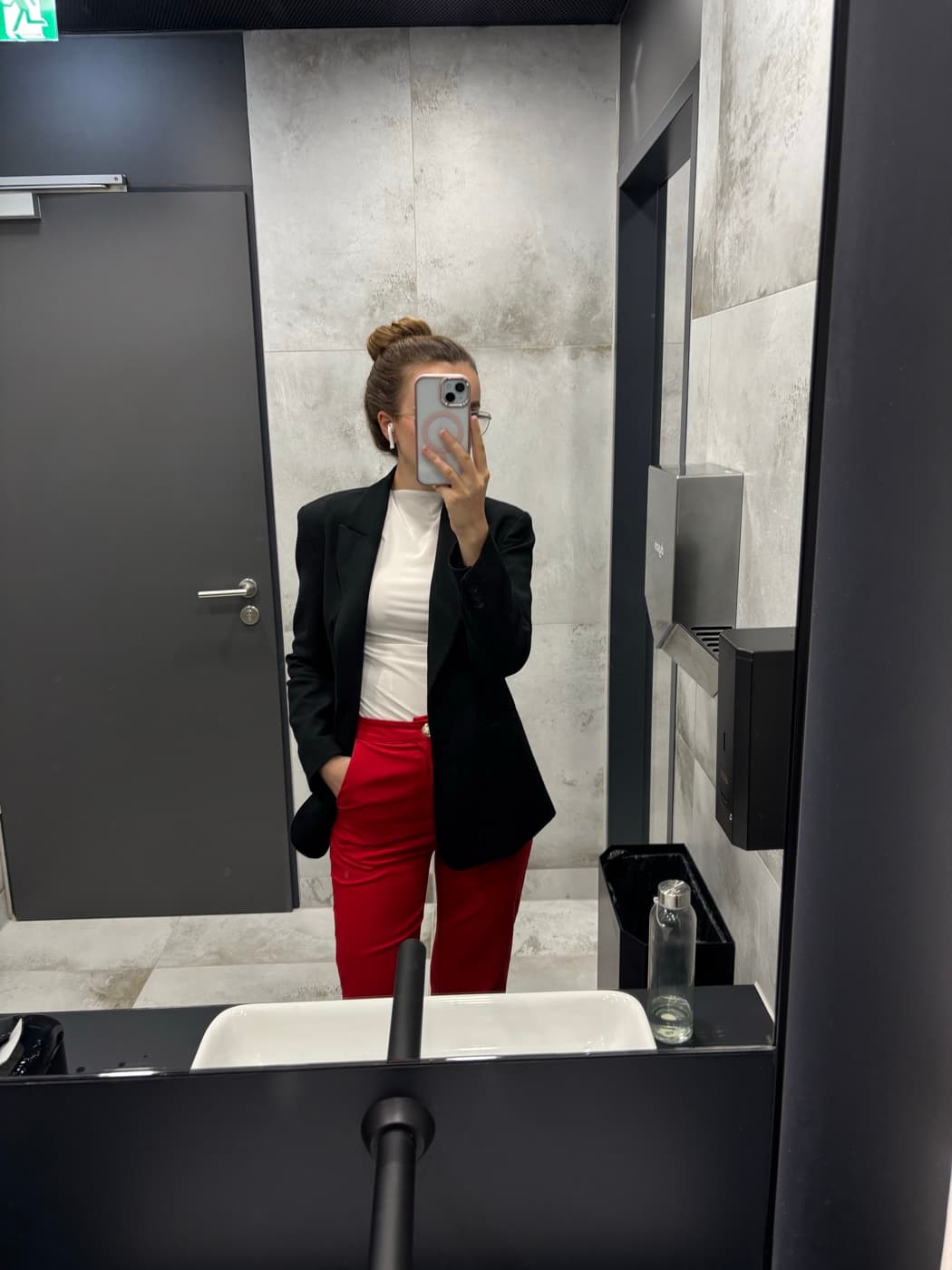 Annamaria in a blazer, photographed in a mirror at an office
