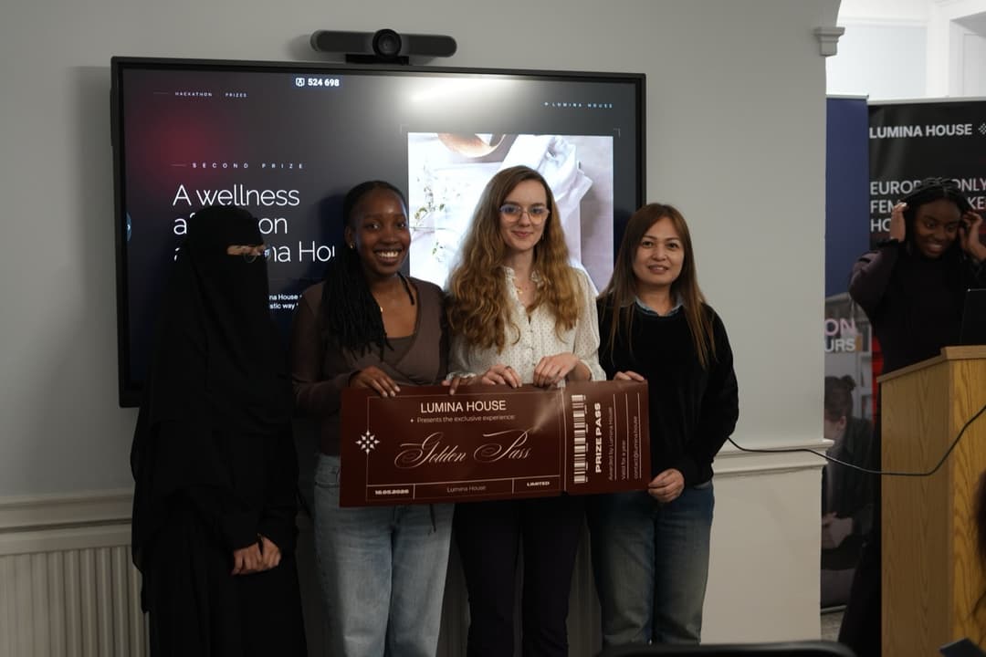 Annamaria and teammates holding a Lumina House hackathon prize pass